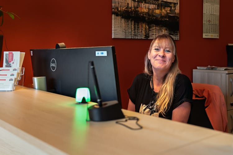 Eine Supportmitarbeiterin am Schalter im WIRO-KundenCenter lächelt freundlich in die Kamera.