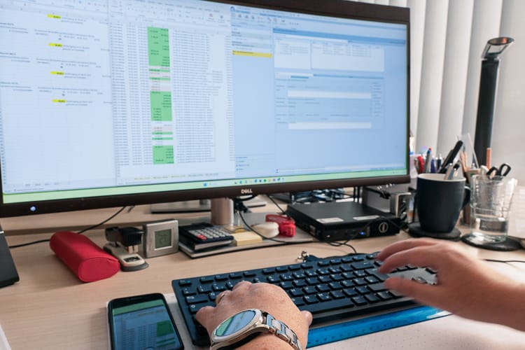 Blick auf einen großen Computermonitor mit vielen Tabellen. 