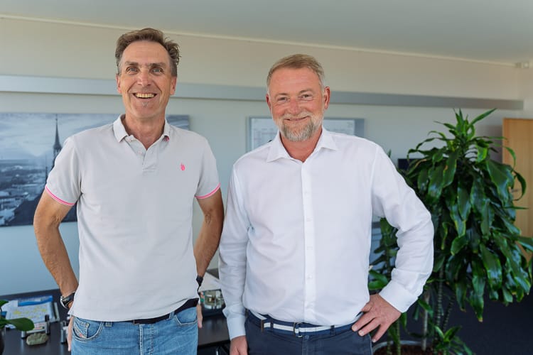 Die beiden Geschäftsführer der WIRO blicken freundlich in die Kamera.